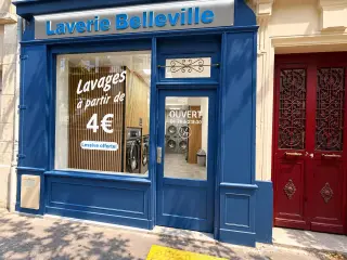 Devanture bleue de la laverie à côté de la porte cochère rouge